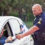 Police officer handing ticket to motorist
