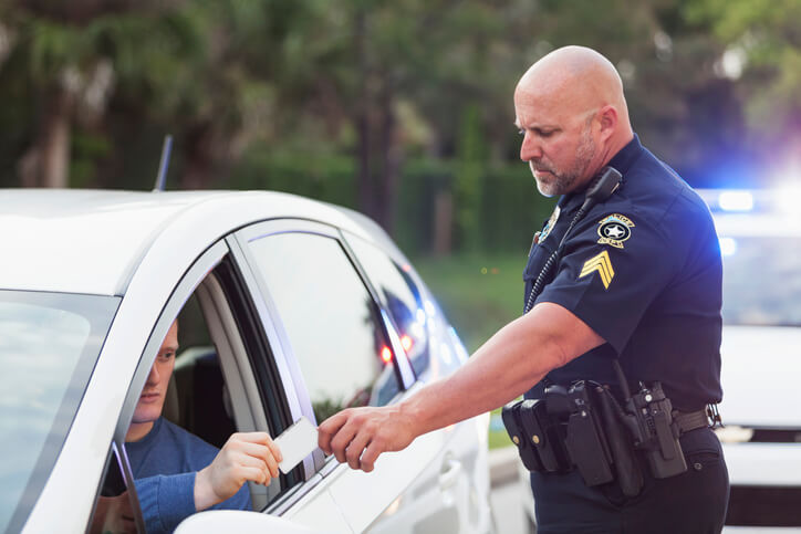 Police officer handing ticket to motorist