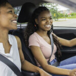 A teenage driver drives with her mother